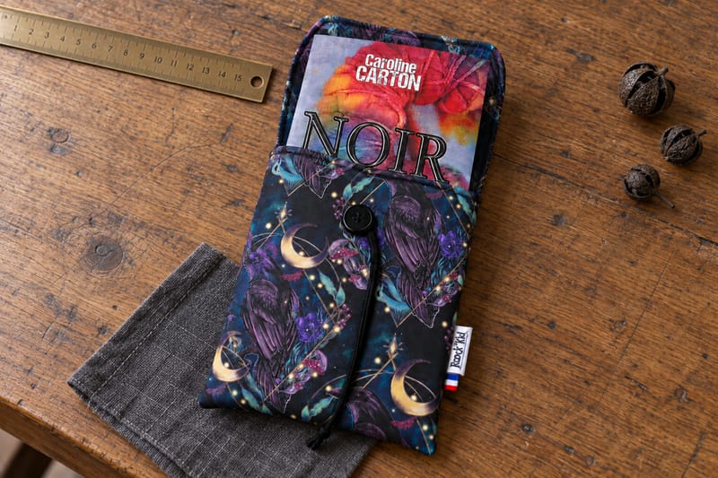 Pochette petit format avec un livre présentée sur une table