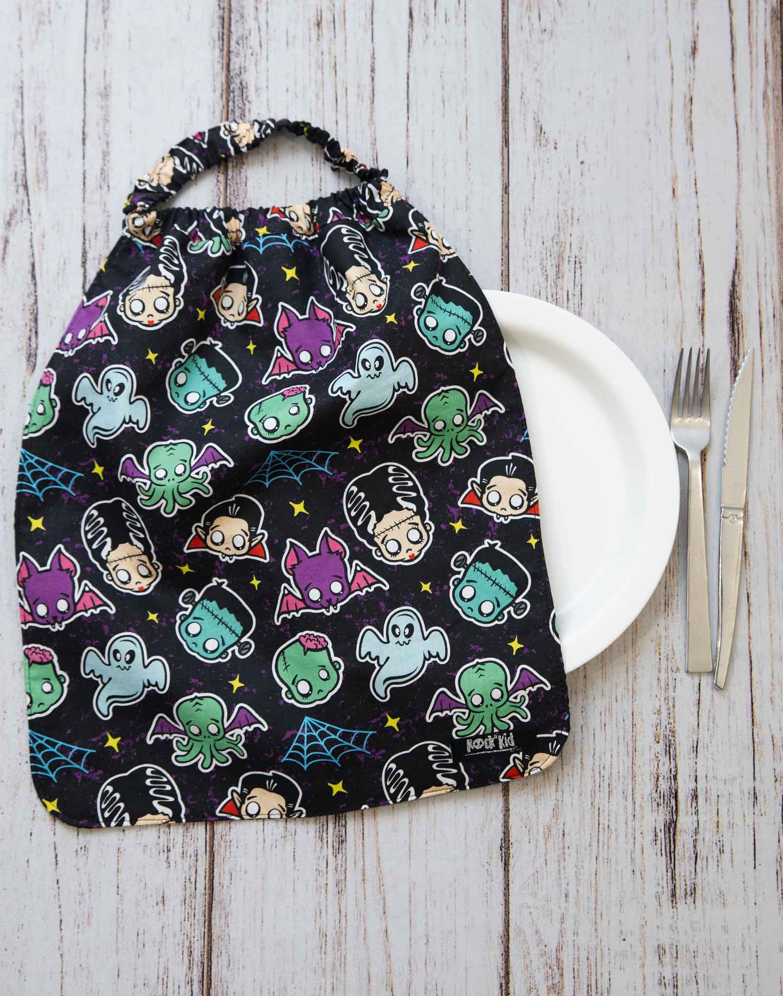 Serviette de table pour enfant avec élastique autour du cou. Cousue main artisanalement en France dans un tissu au design exclusif imprimé à la demande.